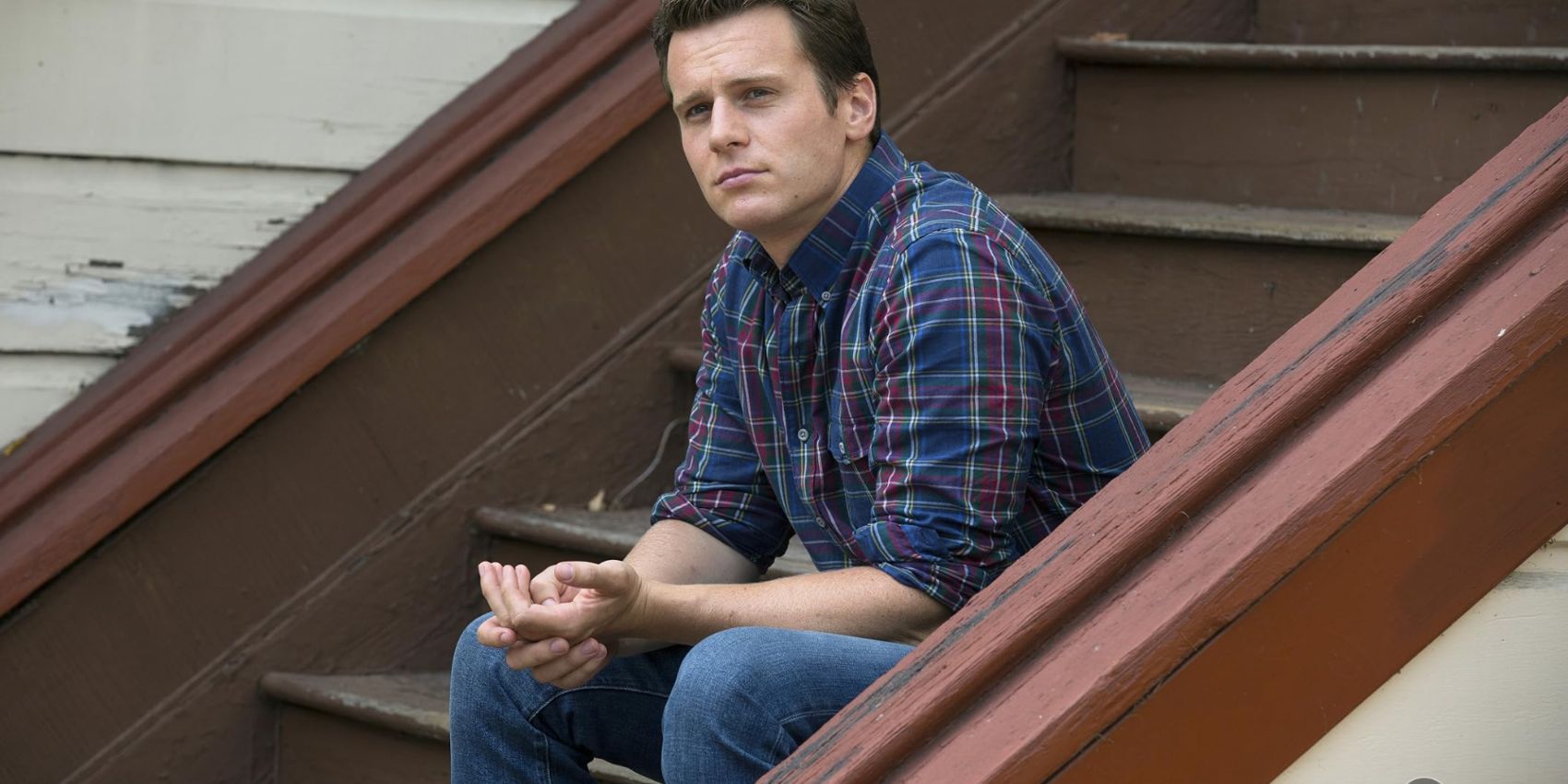 Jonathan Groff in Looking sitting on stoop with serious expression