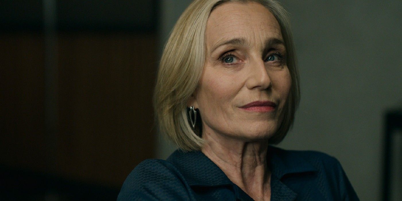 Kristin Scott Thomas in Slow Horses in a solo shot from the shoulders up, wearing a navy blue shirt and looking dubious