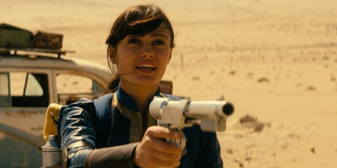 Lucy segurando uma arma de dardo em Fallout