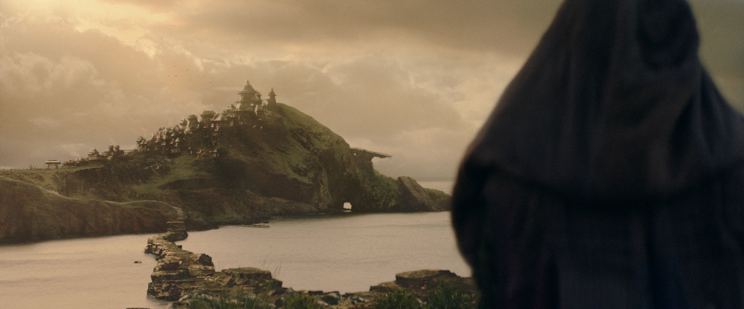 Possivelmente Mae (Amandla Stenberg) olhando para uma trilha que leva a uma vila costeira em uma colina em Star Wars: The Acolyte