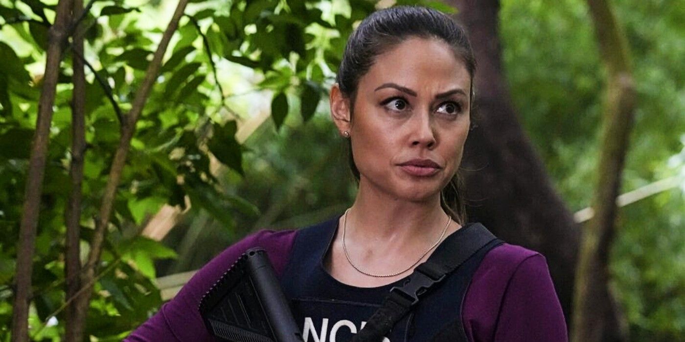 Major Jane Tennant holds a gun and wears tactical gear in the forest in NCIS Hawaii Season 3