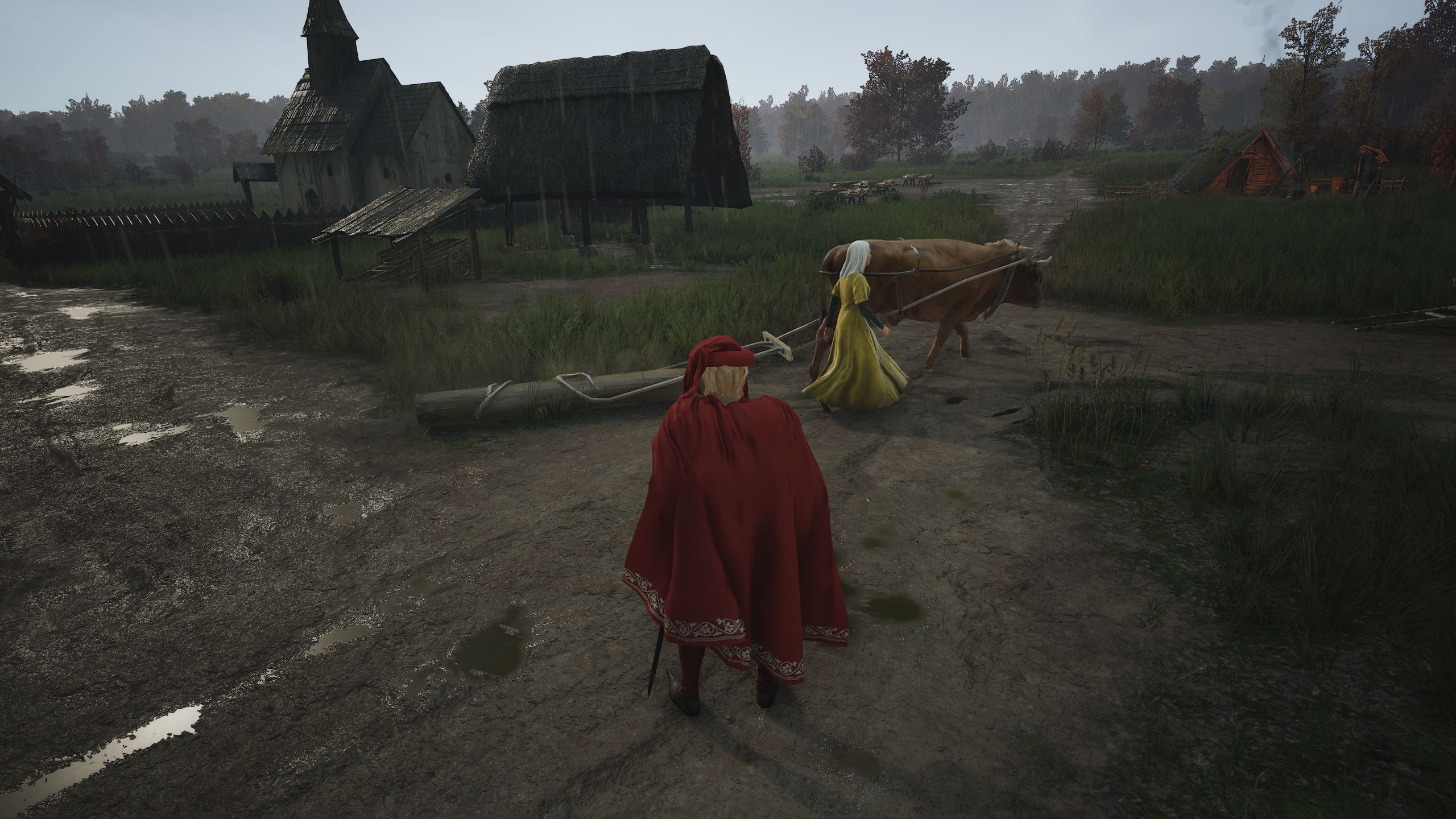 Jogador do Manor Lords em vestes vermelhas observando bois-guia do aldeão carregando toras de madeira ao longo da estrada de terra