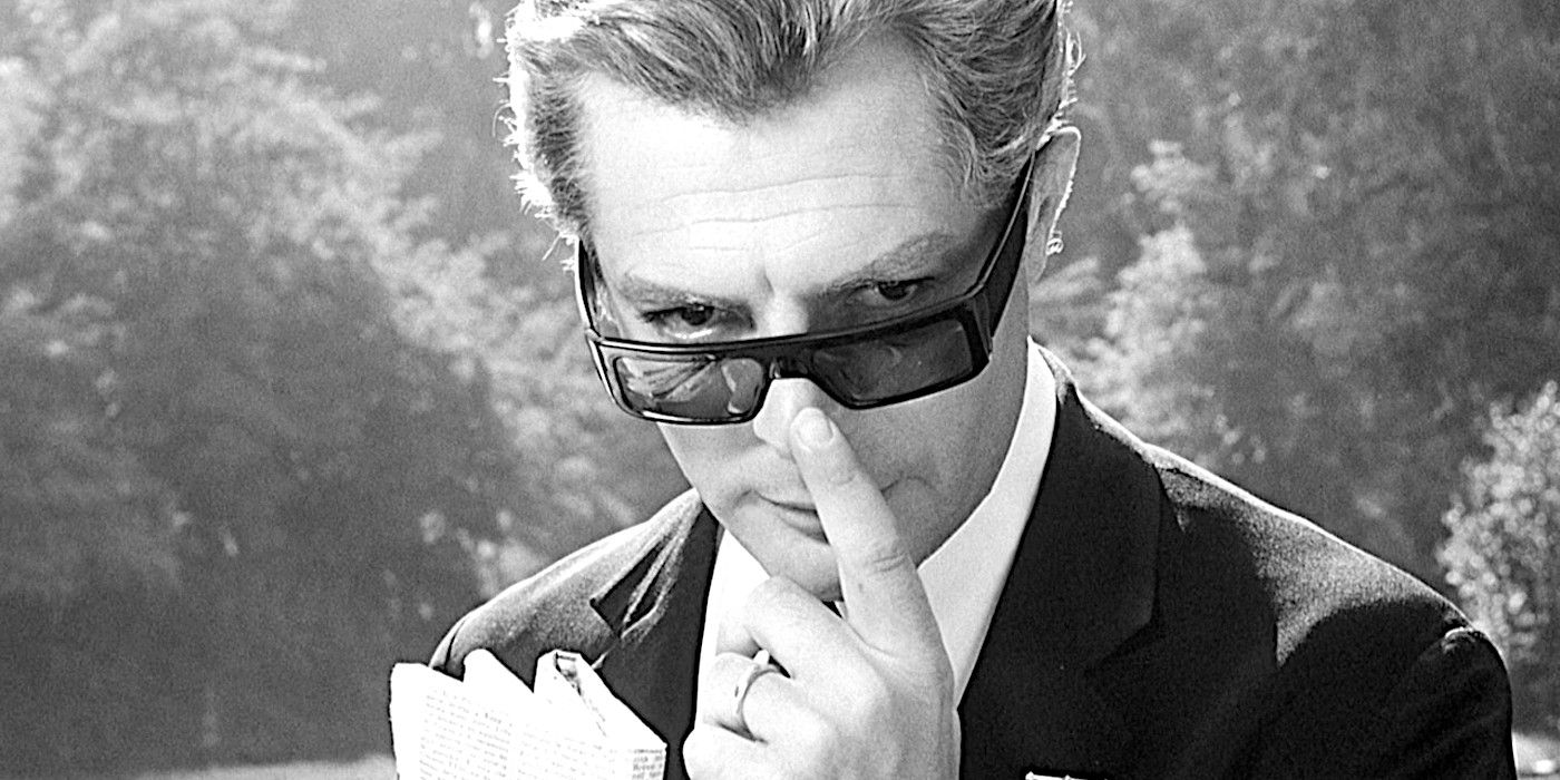 Marcello Mastroianni peers mysteriously over his glasses in a scene from 8 1/2