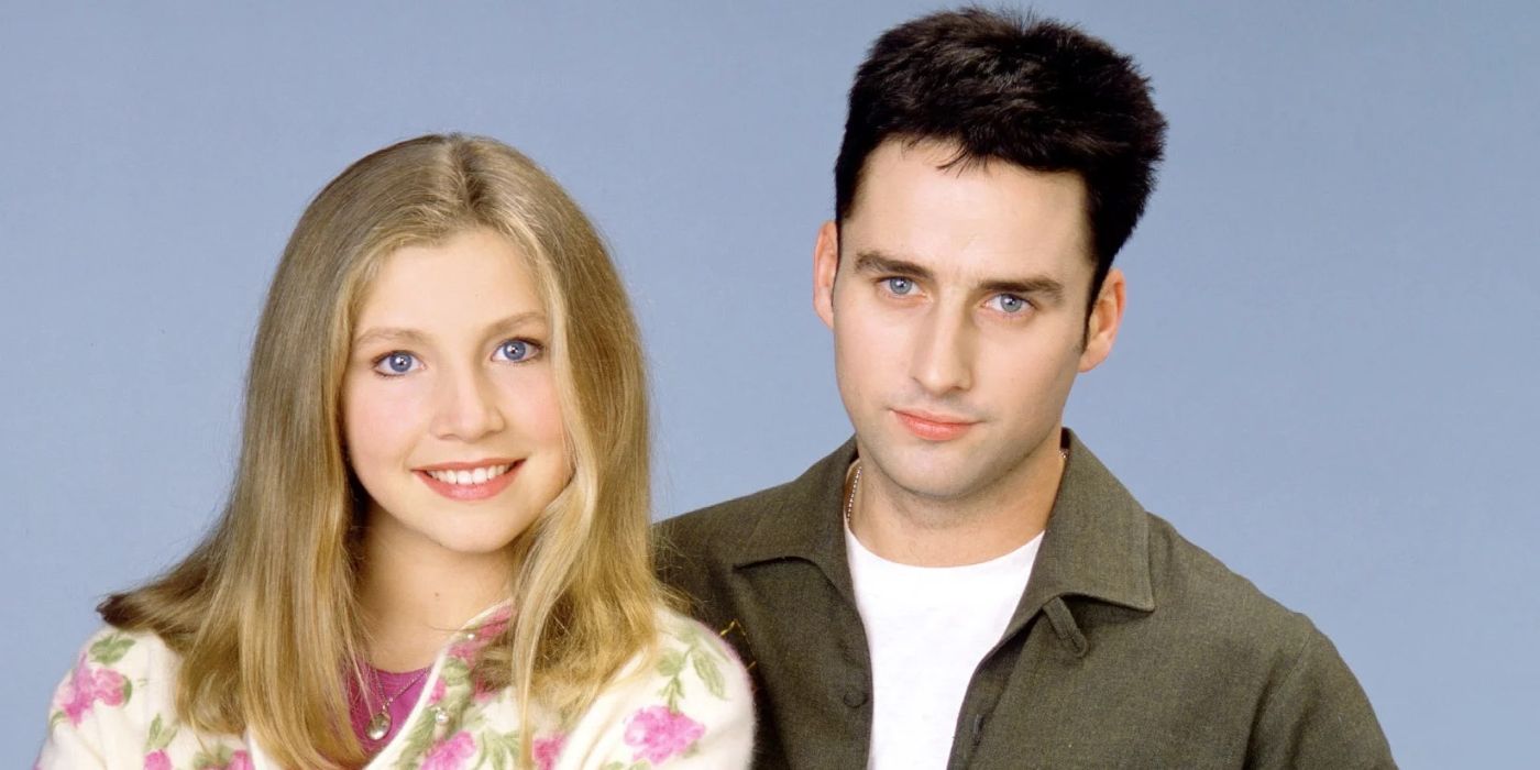 Mark Healy (Glenn Quinn) standing next to Becky Conner (Sarah Chalke) and smiling in Roseanne.