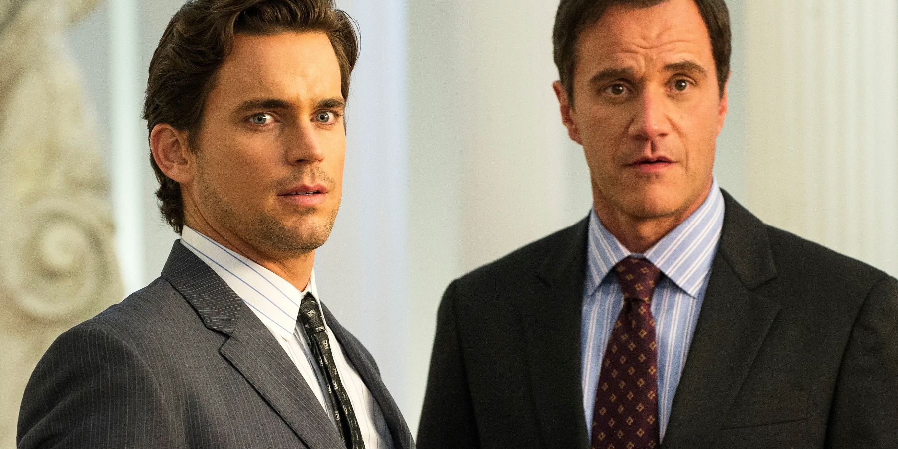 Matt Bomer as Neal Caffrey and Tim Dekay as Peter Burke standing next to each other and appearing amused in White Collar
