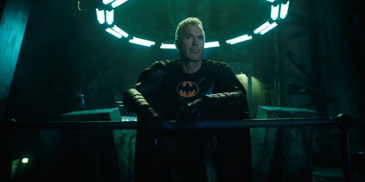 Michael Keaton as Batman standing in the batcave under a ring of lights in The Flash