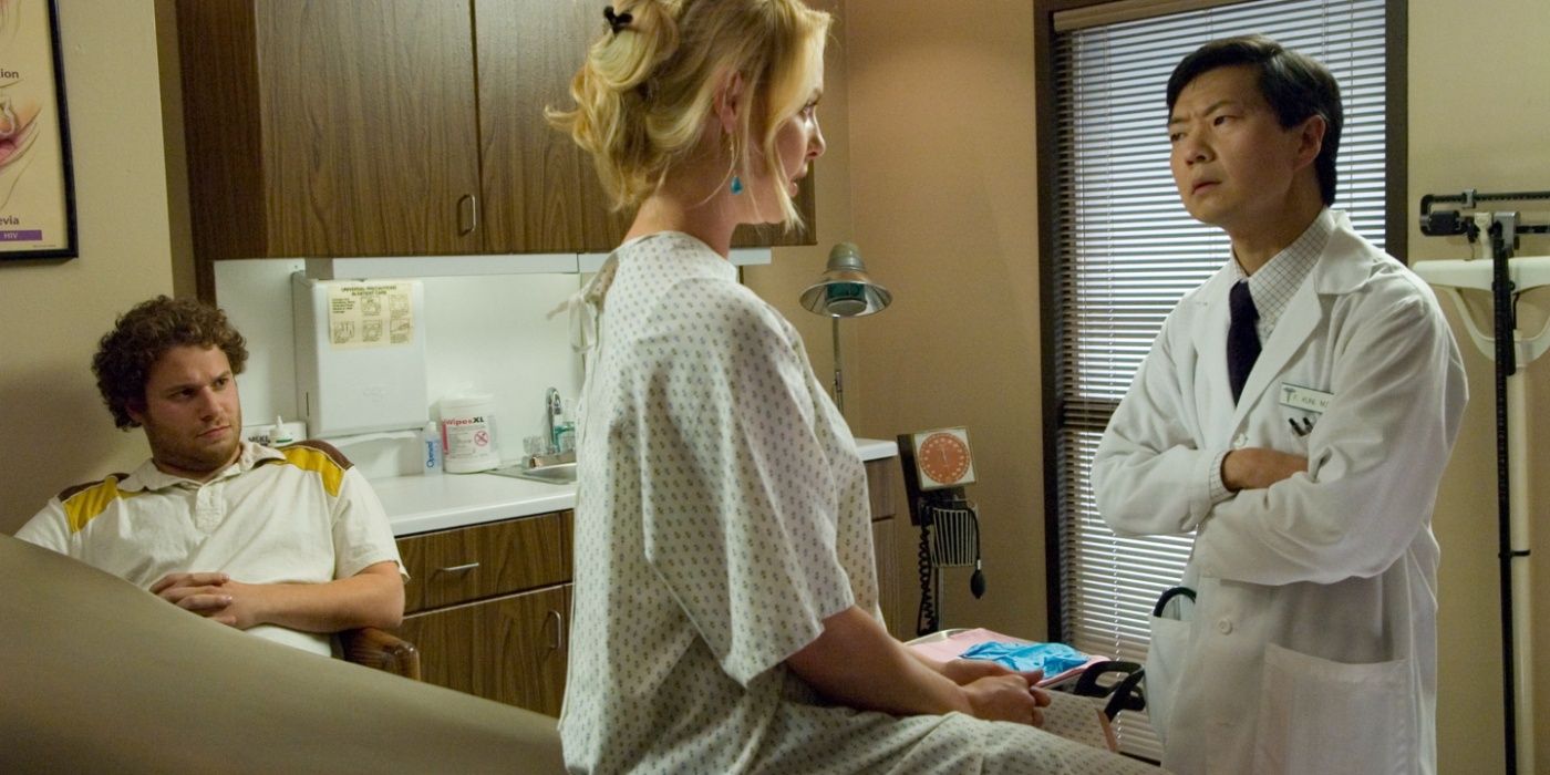 Ken Jeong como um médico olhando com desconfiança para Alison (Katherine Heigl) enquanto Ben (Seth Rogen) observa no canto em Knocked Up