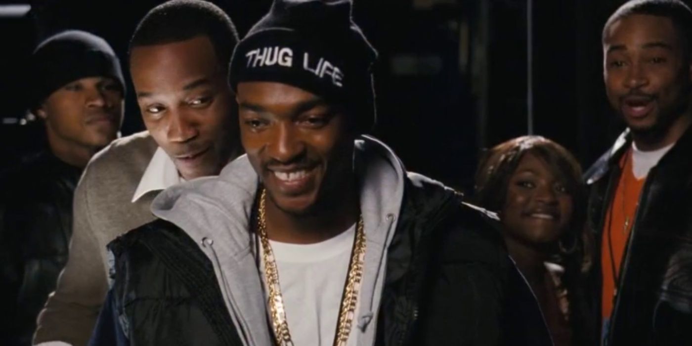 Tupac (Anthony Mackie) sorrindo e usando um chapéu que diz “Thug Life” em Notorious