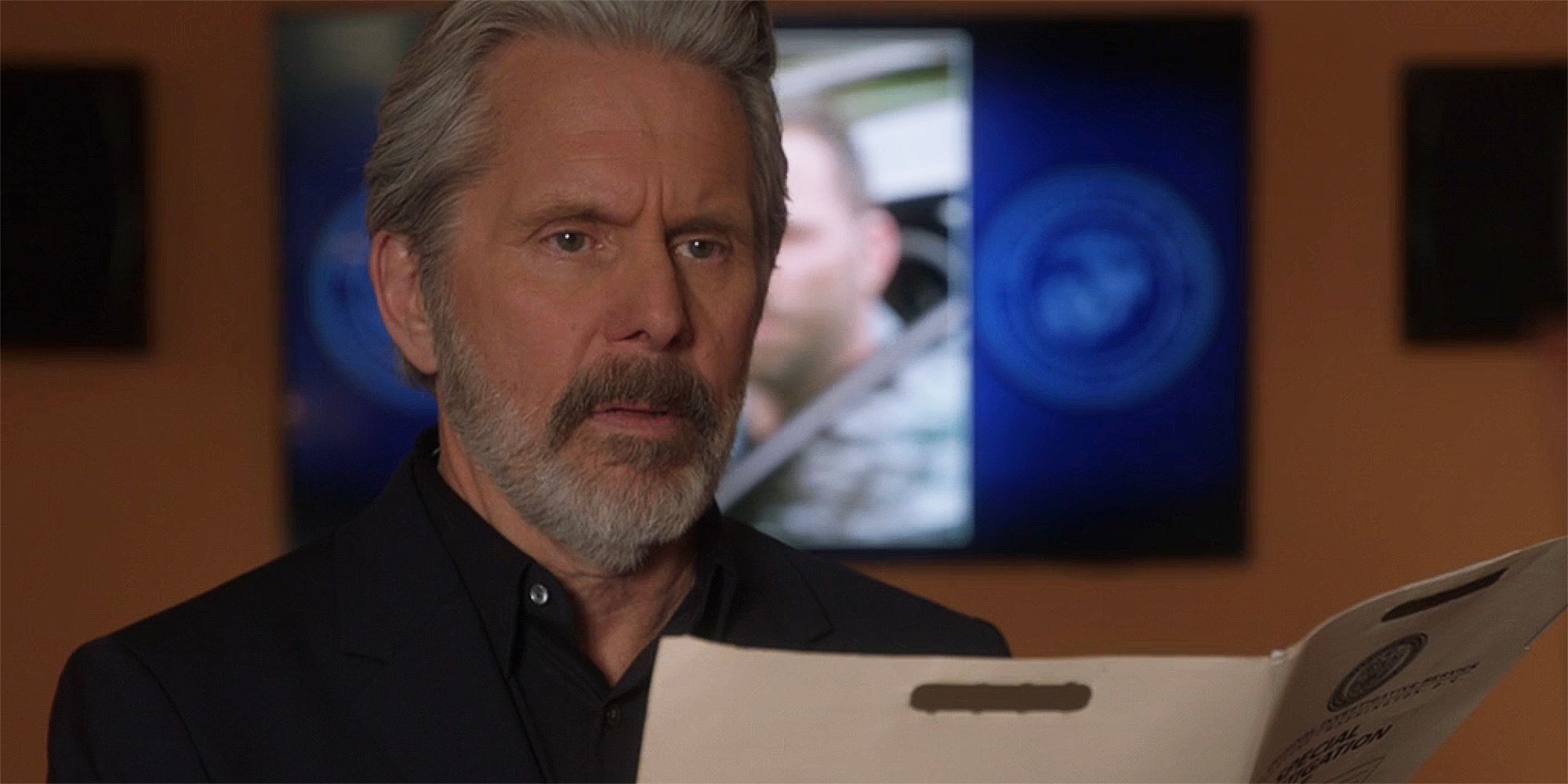 Gray Cole as Alden Parker holding an open folder in NCIS