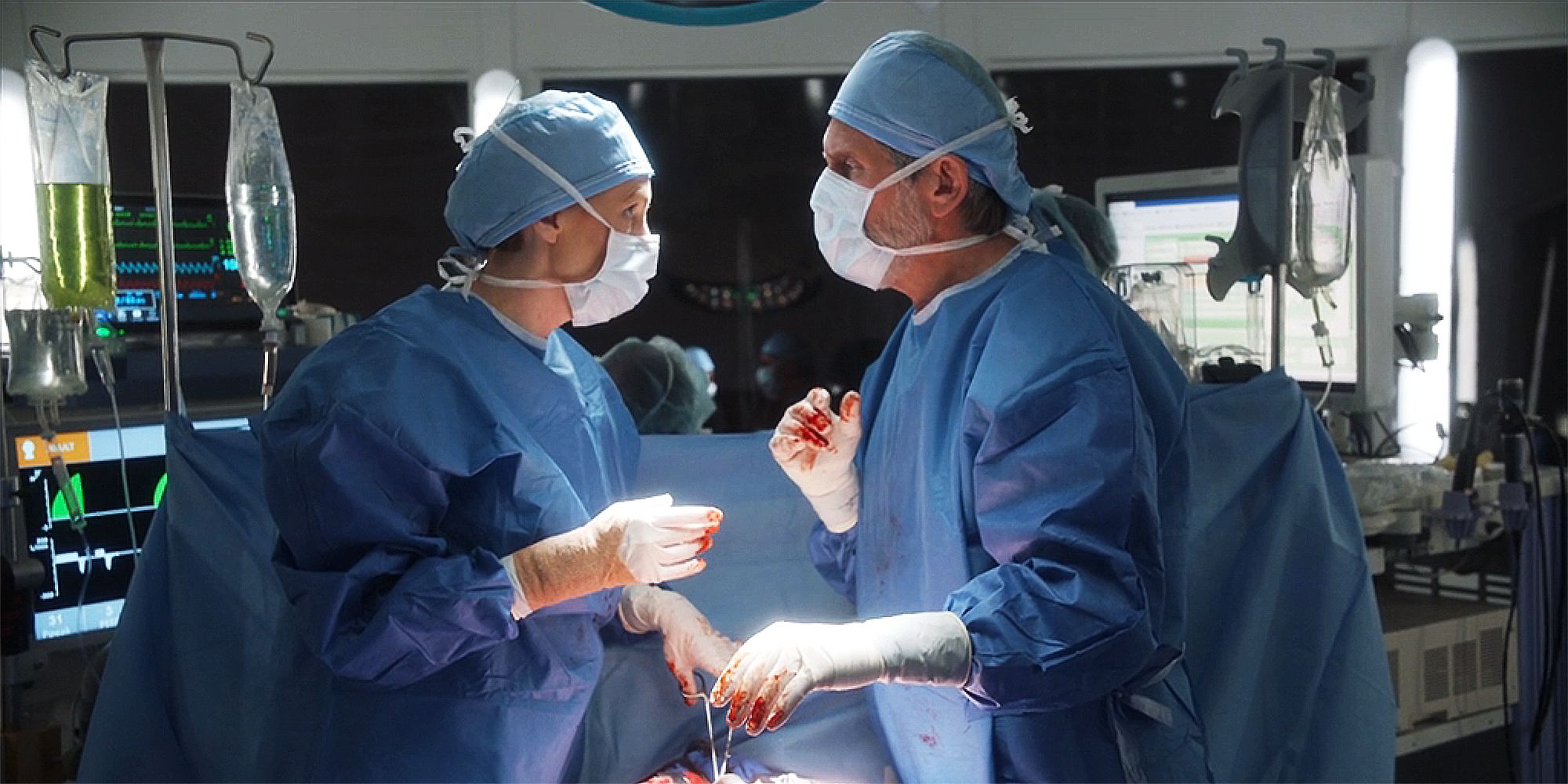 Clara Logan and Alden Parker stand in operating room with blood on their gloved hands