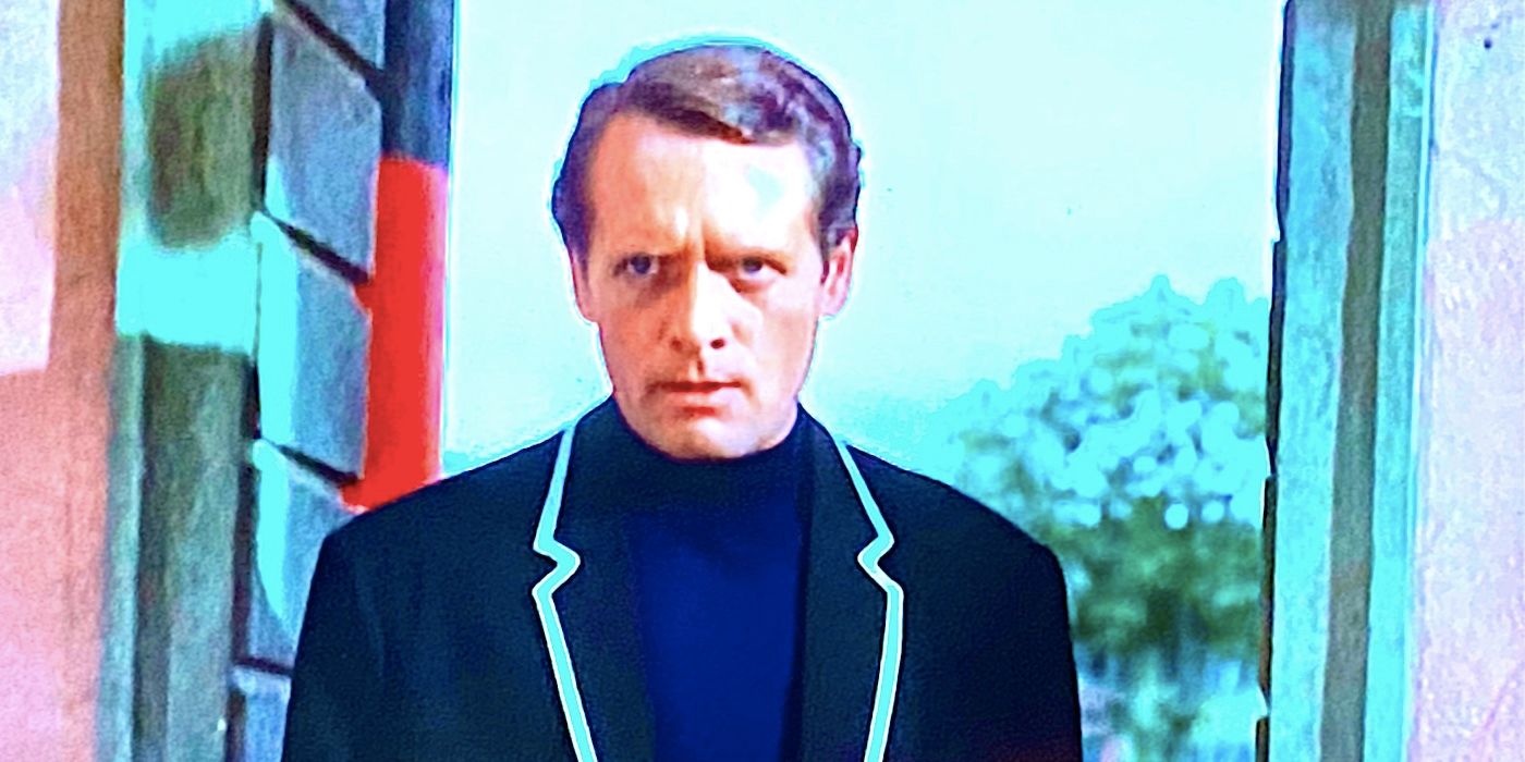 Patrick McGoohan's Number Six frowns in a stone walkway in The Prisoner 1967