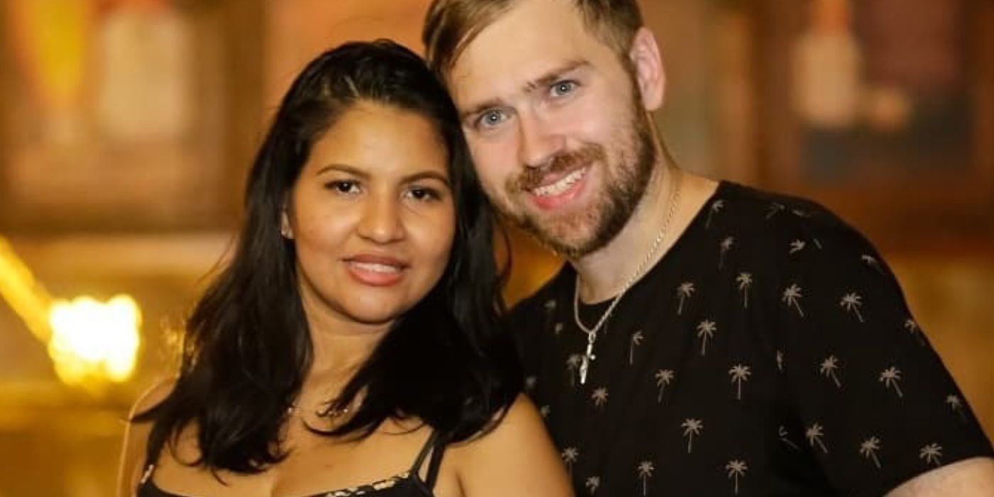 Paul Staehle in black t-shirt and Karine in strappy black dress in 90 Day Fiance standing side by side.