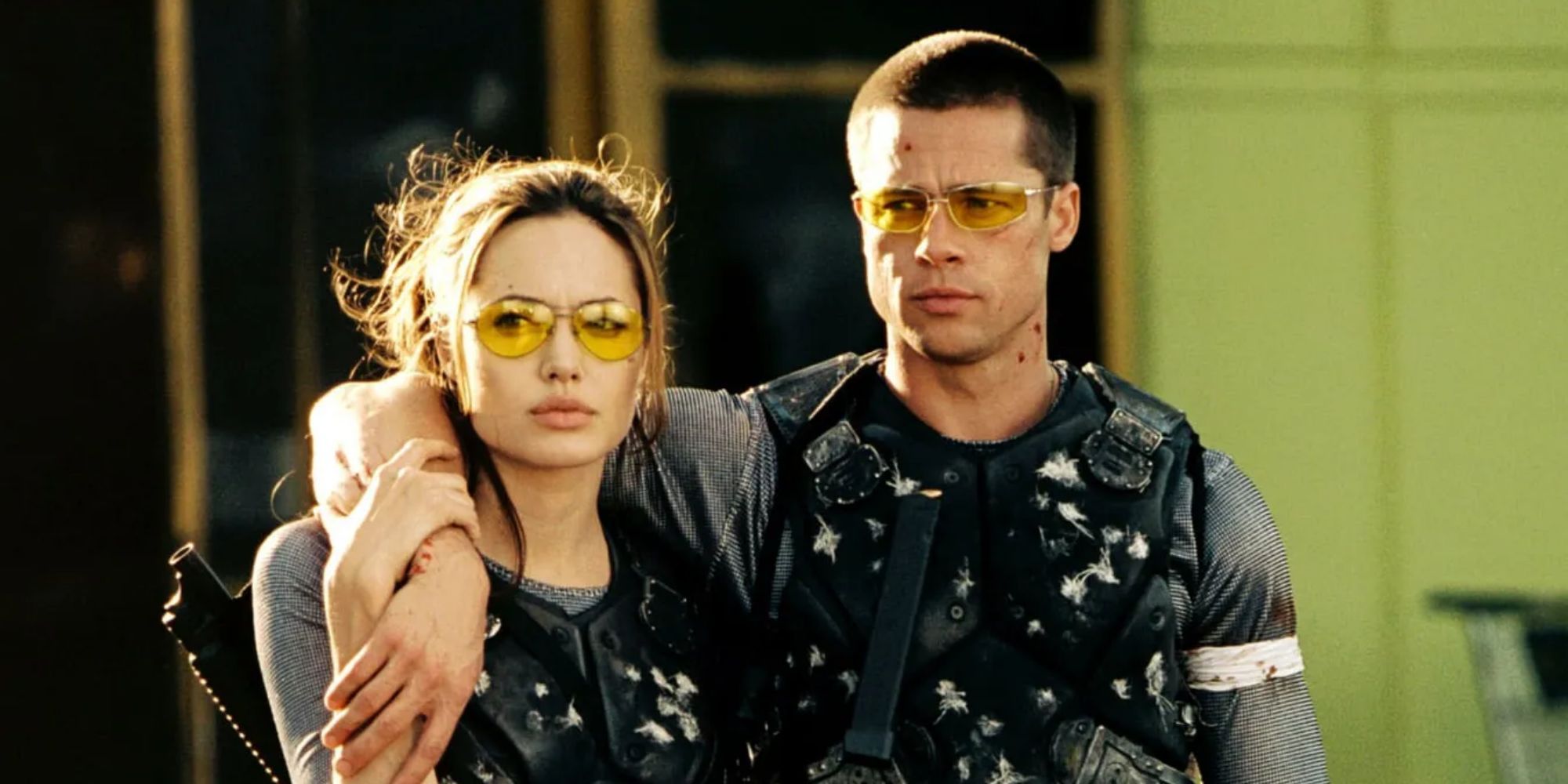 John (Brad Pitt) and Jane (Angelina Jolie) carrying each other and wearing bulletproof vests in Mr. & Mrs. Smith