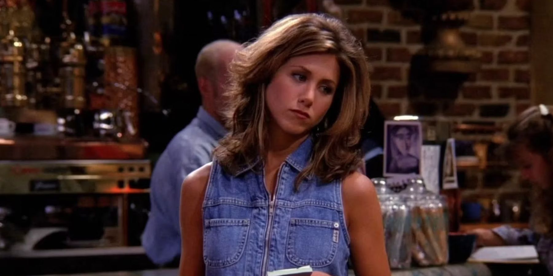 Rachel tilting her head to the side and waiting to take an order at Central Perk in Friends