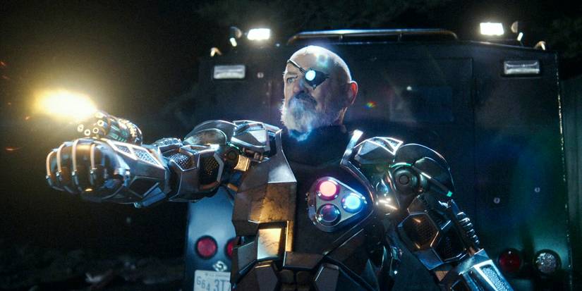 Peter Bach with a very high tech armoir suit shoothing somethin from his wrist weapon in Resident Alien season 3 episode 8