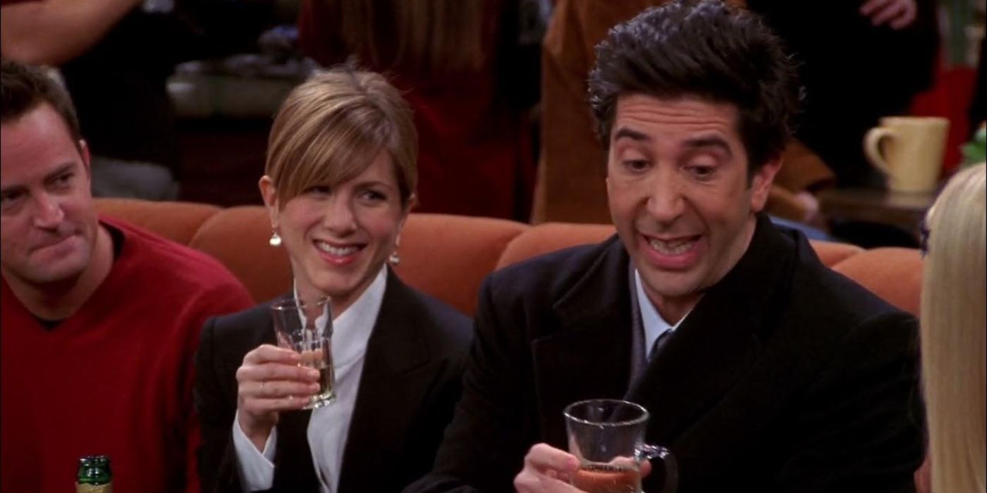 Ross Rachel e Chandler sentados no sofá do Central Perk bebendo champanhe em Friends.