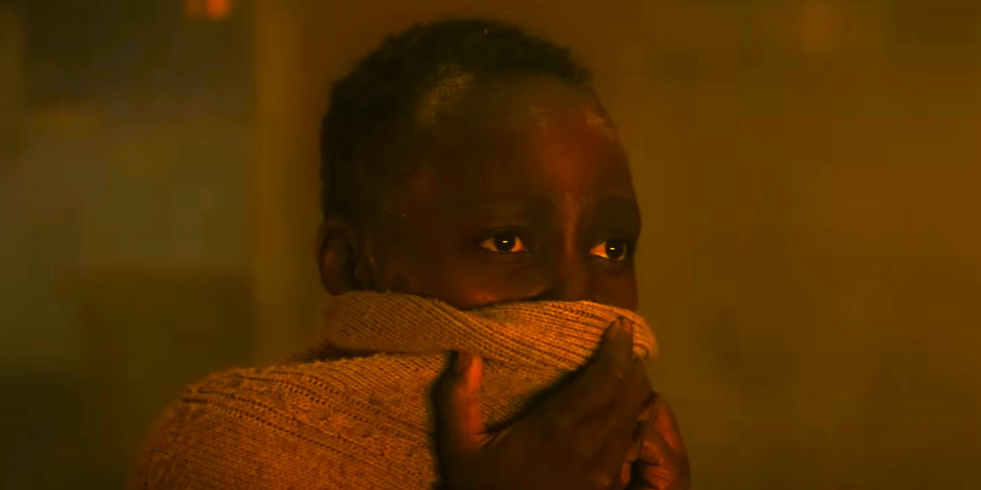 Lupita Nyongo covering her face with dust in her hair in A Quiet Place Day One