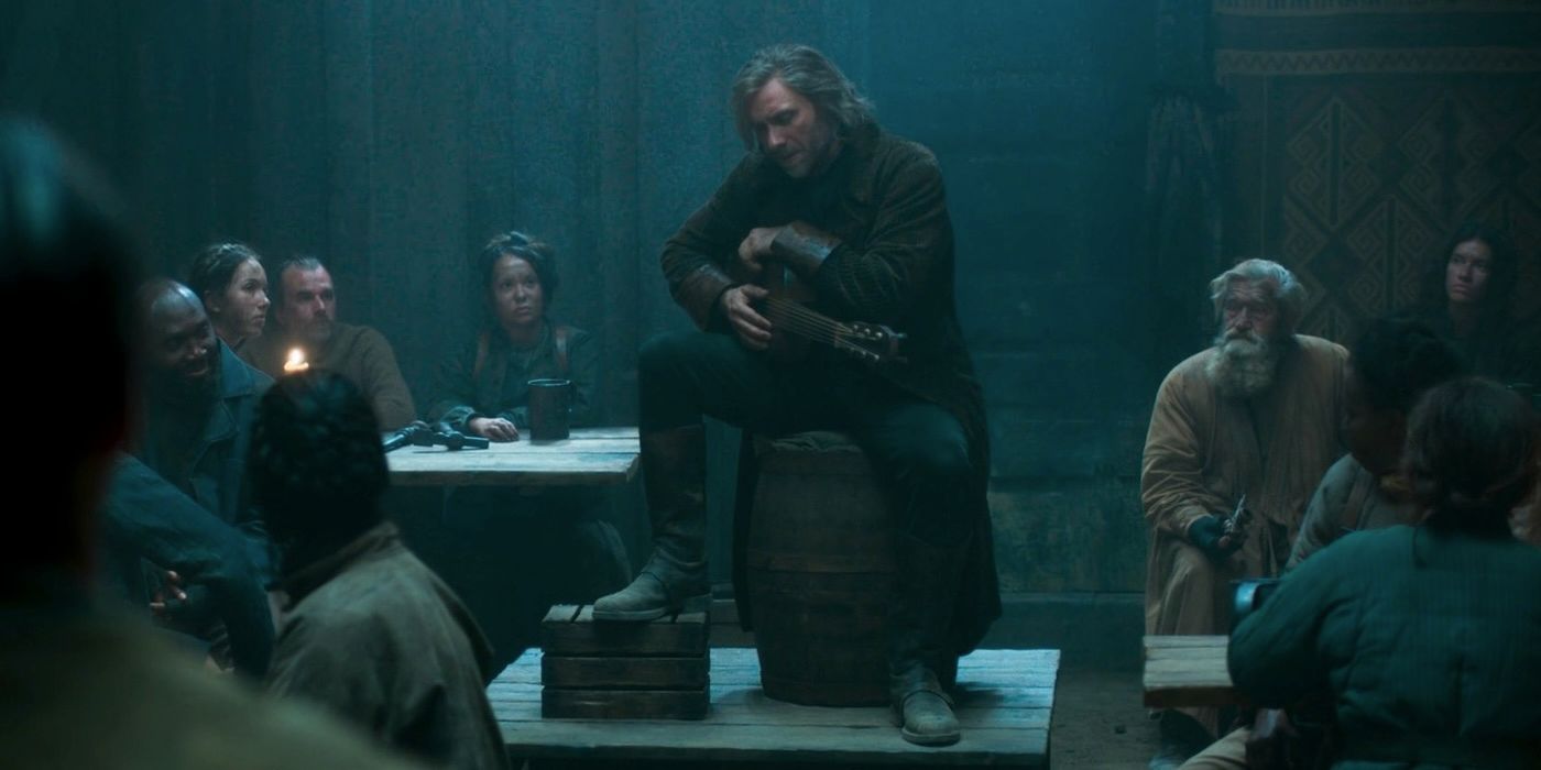 Thom sitting on a barrel in The Wheel of Time.