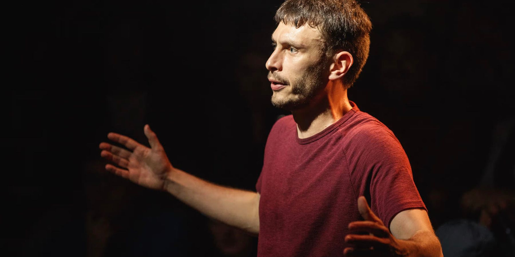 Richard Gadd spreading out his arms while performing his debut solo theater show Baby Reindeer.