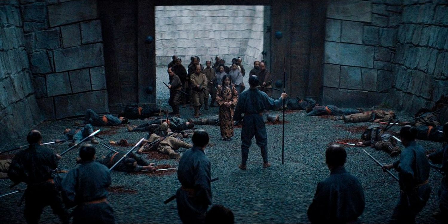 Wide shot of Mariko facing Ishido's warriors, behind her, her own warriors escorting her, and dead warriors on the ground after a battle in Shogun season 1 Ep 9 
