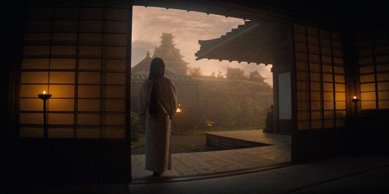 Una toma amplia muestra a Mariko parada de espaldas a la cámara y mirando desde su habitación en el Palacio de Osaka en Shogun Temporada 1 Episodio 9. 