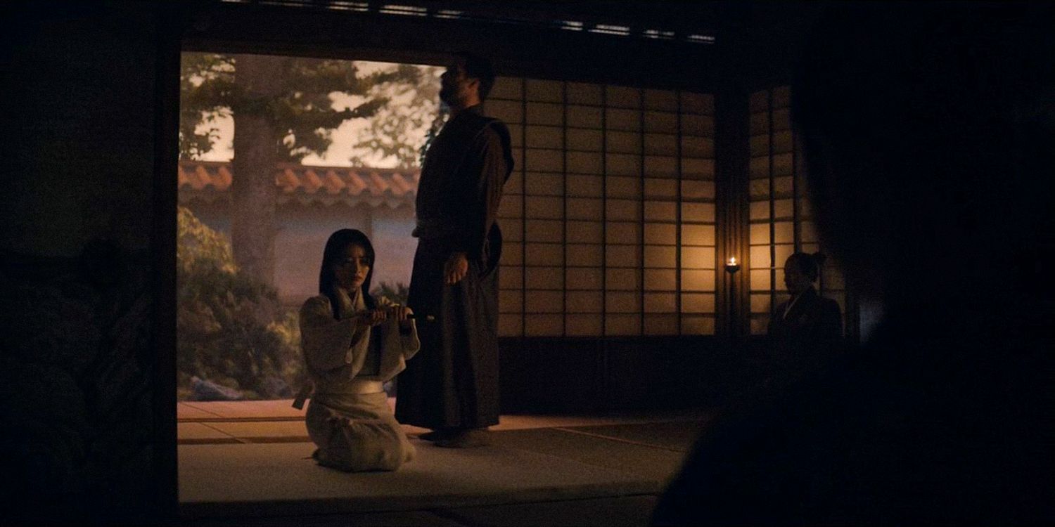 Blackthorne stands beside Mariko, assisting her as her second, while she holds a dagger to her heart in Shogun season 1 Ep 9 