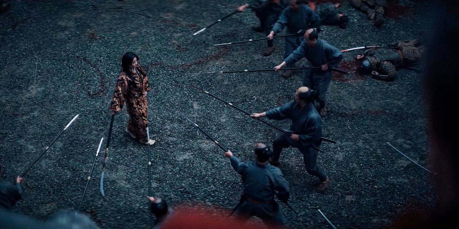 An aerial shot of Mariko walking peacefully with a sword in her hand while some warriors surround her threateningly with spears in Shogun season 1 ep 9 trailer