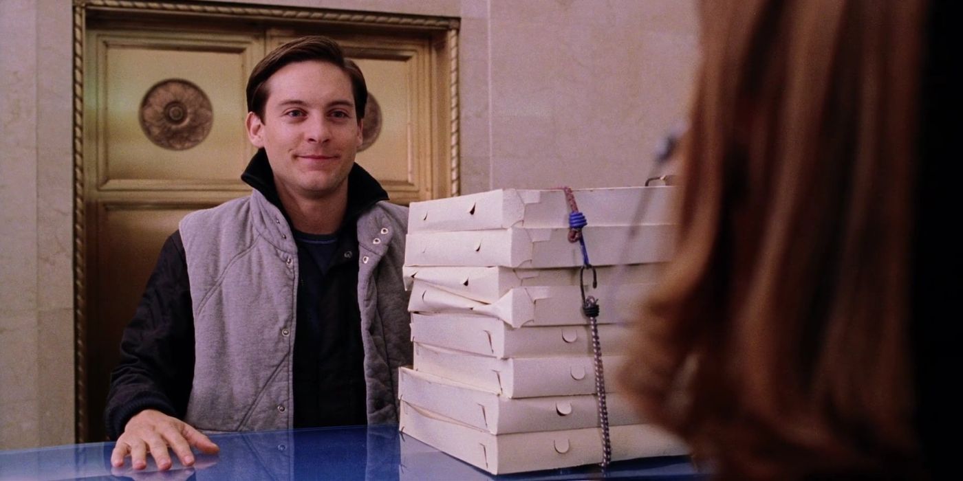 Homem-Aranha 2 (2004) Peter Parker segurando uma grande torre de pizzas em Homem-Aranha 2