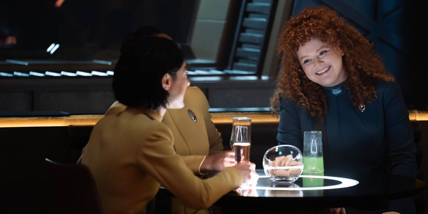 Tilly sitting at a bar table with other star fleet officers smiling radiantly Tilly sitting at a bar table with other star fleet officers smiling radiantly