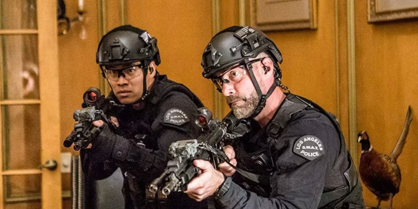 Tan e Deacon uniformizados e com armas em punho dentro de uma casa no episódio da SWAT Invisível