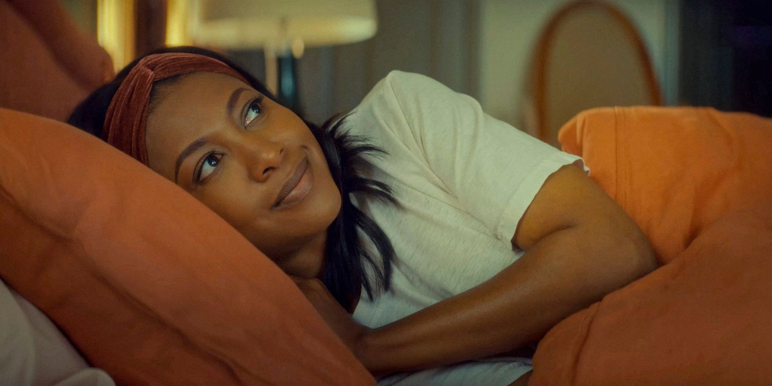 Cass (Gabrielle Dennis) sorri enquanto está deitada em sua cama na 2ª temporada do The Big Door Prize