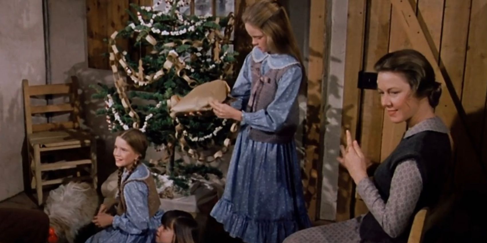 A família abrindo seus presentes perto de uma árvore decorada no episódio Little House on the Prairie Natal em Plum Creek