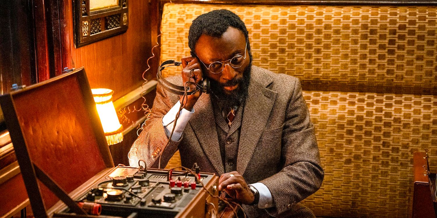 Babs Olusanmokun como Heron usando um transmissor de rádio em The Ministry of Ungentlemanly Warfare