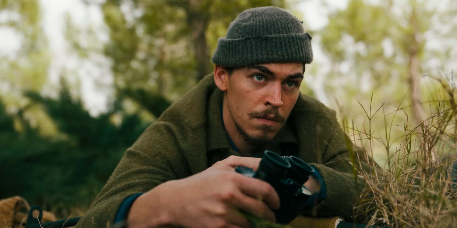 Henry Hayes (Hero Fiennes Tiffin) lies prone holding a pair of binoculars in The Ministry of Ungentlemanly Warfare trailer