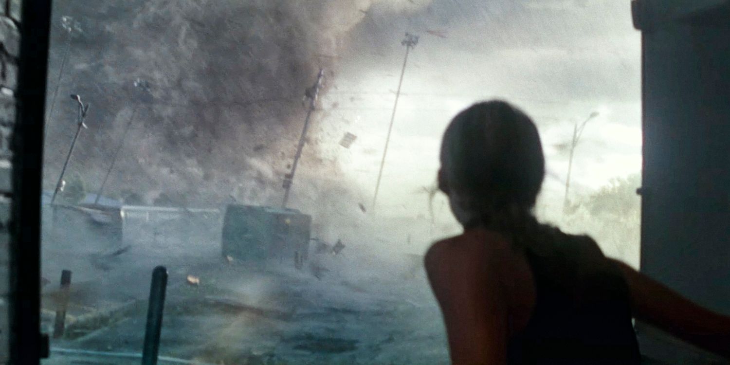 A woman watches a large tornado approaching in Twisters (2024)
