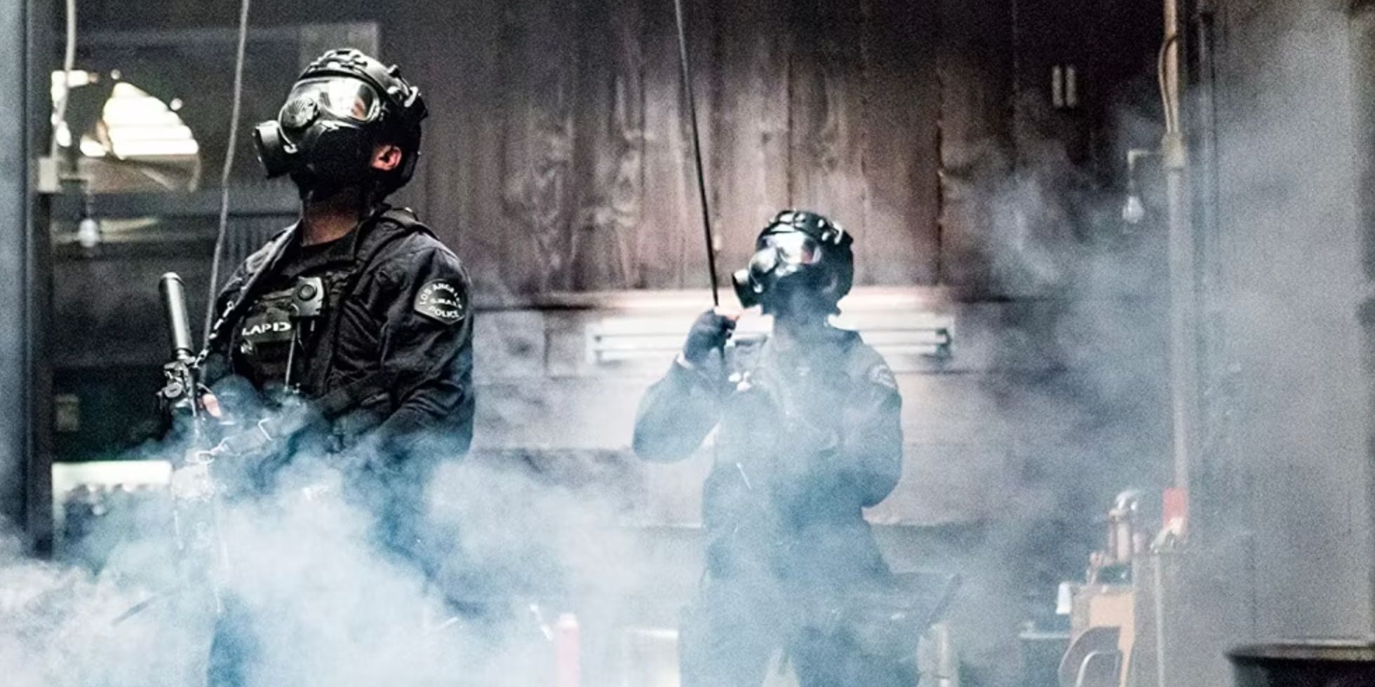 Dois policiais com uniformes e máscaras de gás enquanto uma granada de fumaça é lançada no episódio Kangaroo da SWAT