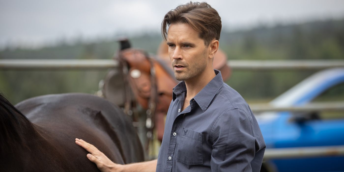 Ty (Graham Wardle) petting a horse and looking worried in Heartland.