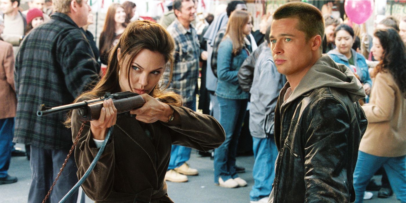 John (Brad Pitt) watching Jane (Angelina Jolie) confidently aiming a gun in Mr. and Mrs. Smith 