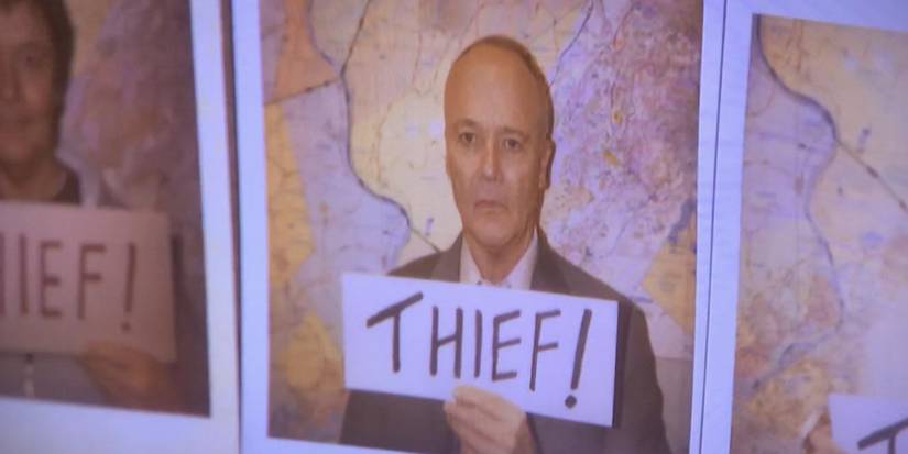 Creed Bratton holding a thief sign in The Office