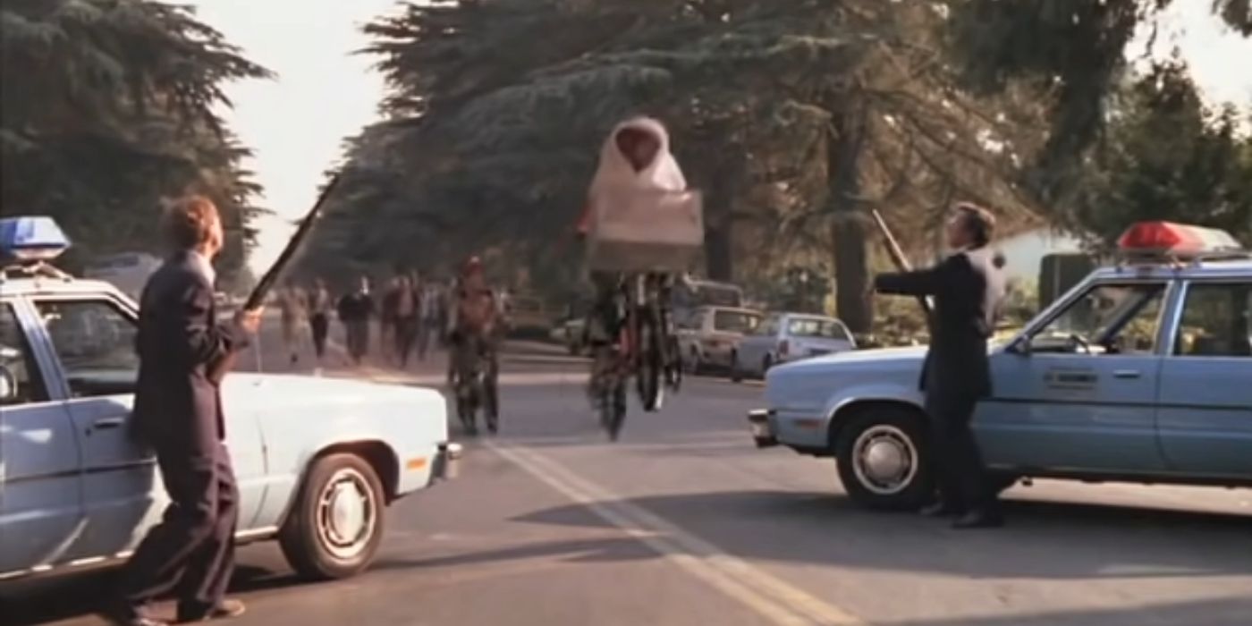 Elliott e ET voando de bicicleta sobre dois carros de polícia em ET O Extraterrestre