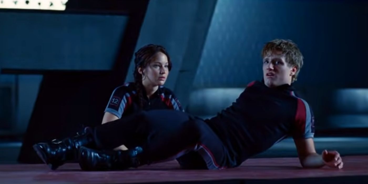 Katniss sat at Peeta's side after he falls from the rope ladder in The Hunger Games