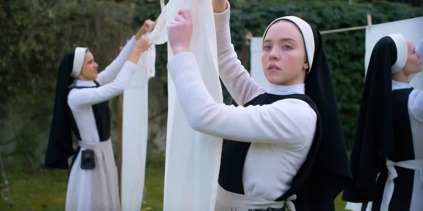 Sydney Sweeney as Sister Cecilia hangs clothing in Immaculate