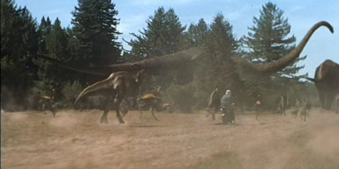 Uma motocicleta andando por uma paisagem empoeirada repleta de Mamenchisaurus em The Lost World: Jurassic Park