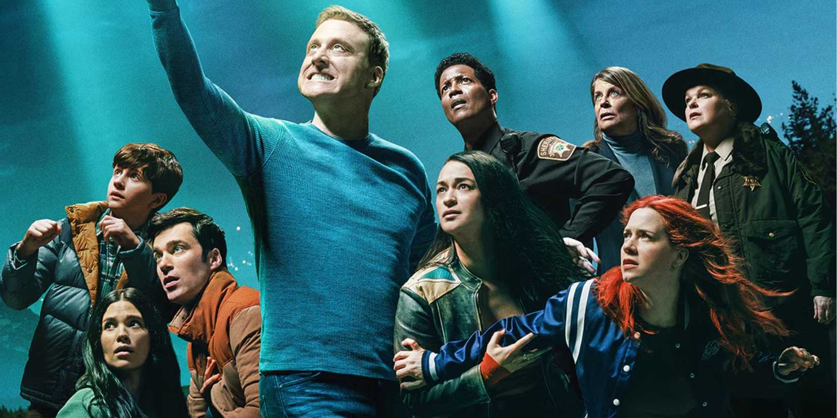 The cast of Resident Alien in a promotional image looking to the sky
