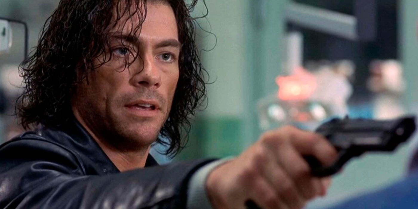 Jean Claude Van Damme with long hair in Replicant holding a gun