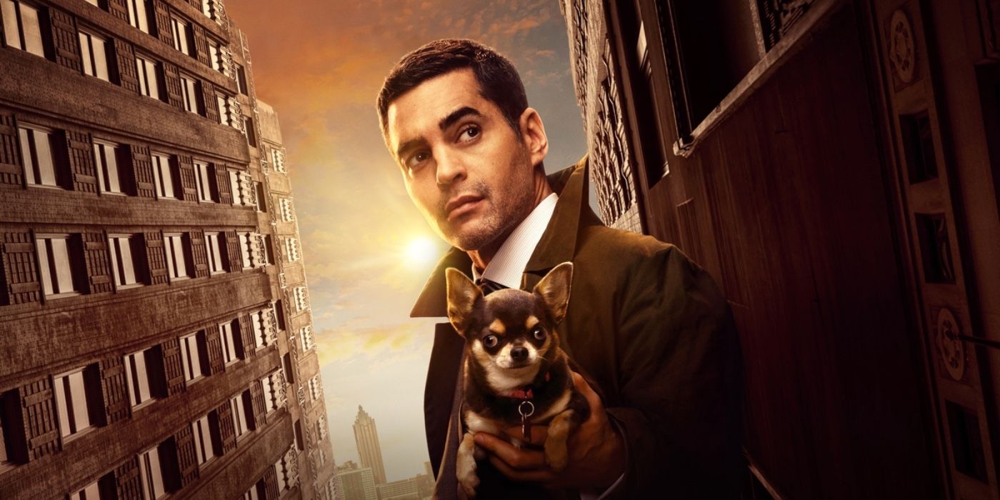 Will Trent holds his dog while silhouetted against the sun and tall building in a Will Trent season 2 promo image.