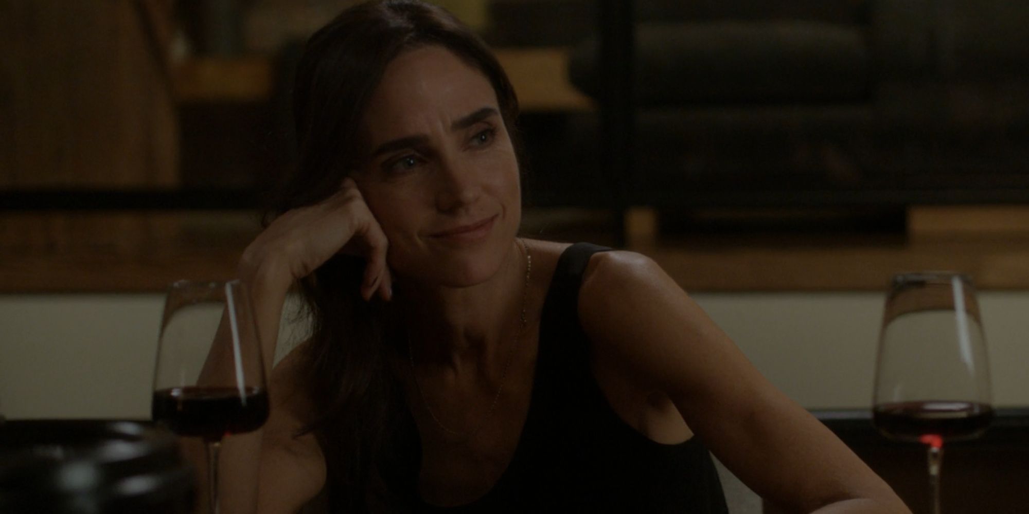 Jennifer Connelly smiling as Daniela Vargas with a glass of red wine in Dark Matter