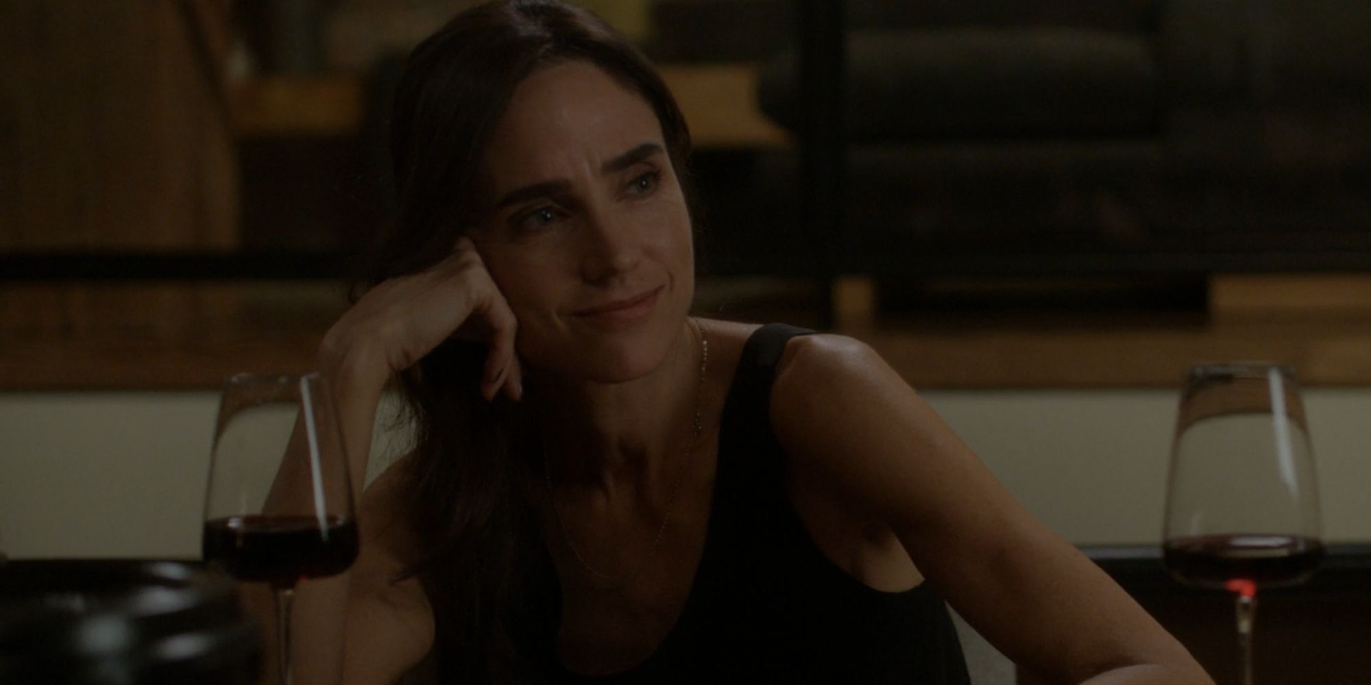 Jennifer Connelly sorrindo como Daniela Vargas com uma taça de vinho tinto em Dark Matter