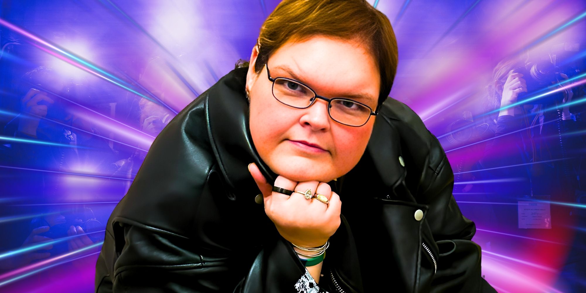 1000-Lb Sisters Tammy Slaton smiles at the camera wearing a black leather jacket with her hand on her chin with blue and purple lazers in the background