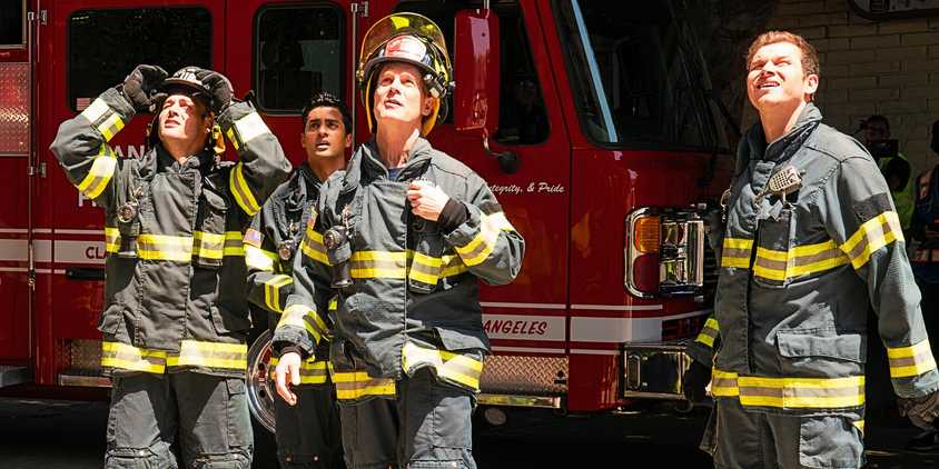 Characters from 9-1-1 including Peter Krause as Bobby Nash, Ryan Guzman as Eddie Diaz, Anirudh Pisharody as Ravi Panikkar, and Oliver Stark as Buck standing in front a fire truck and looking up in season 7 episode 9